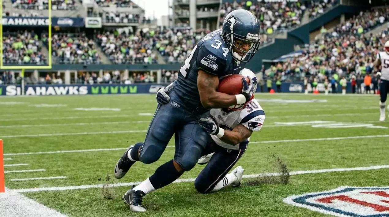 Running back carrying the ball towards the end zone with defensive players closing in