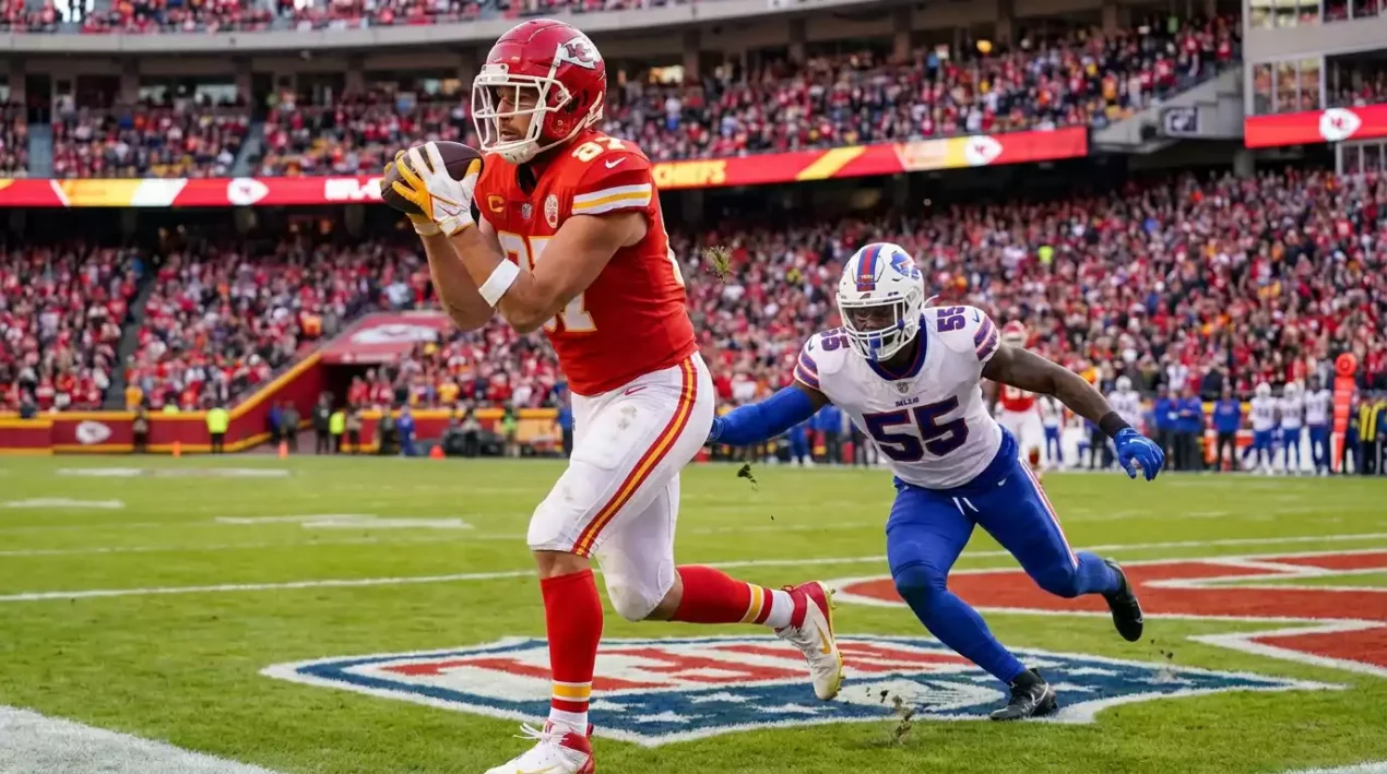 Tight end catching a pass near the goal line with a defender trailing behind